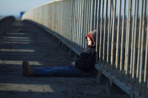 young homeless boy sleeping on the bridge
